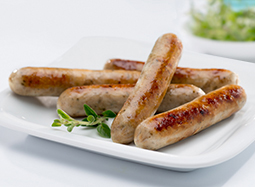 5 kleine, gebratene Bratwürstchen auf einem Teller.